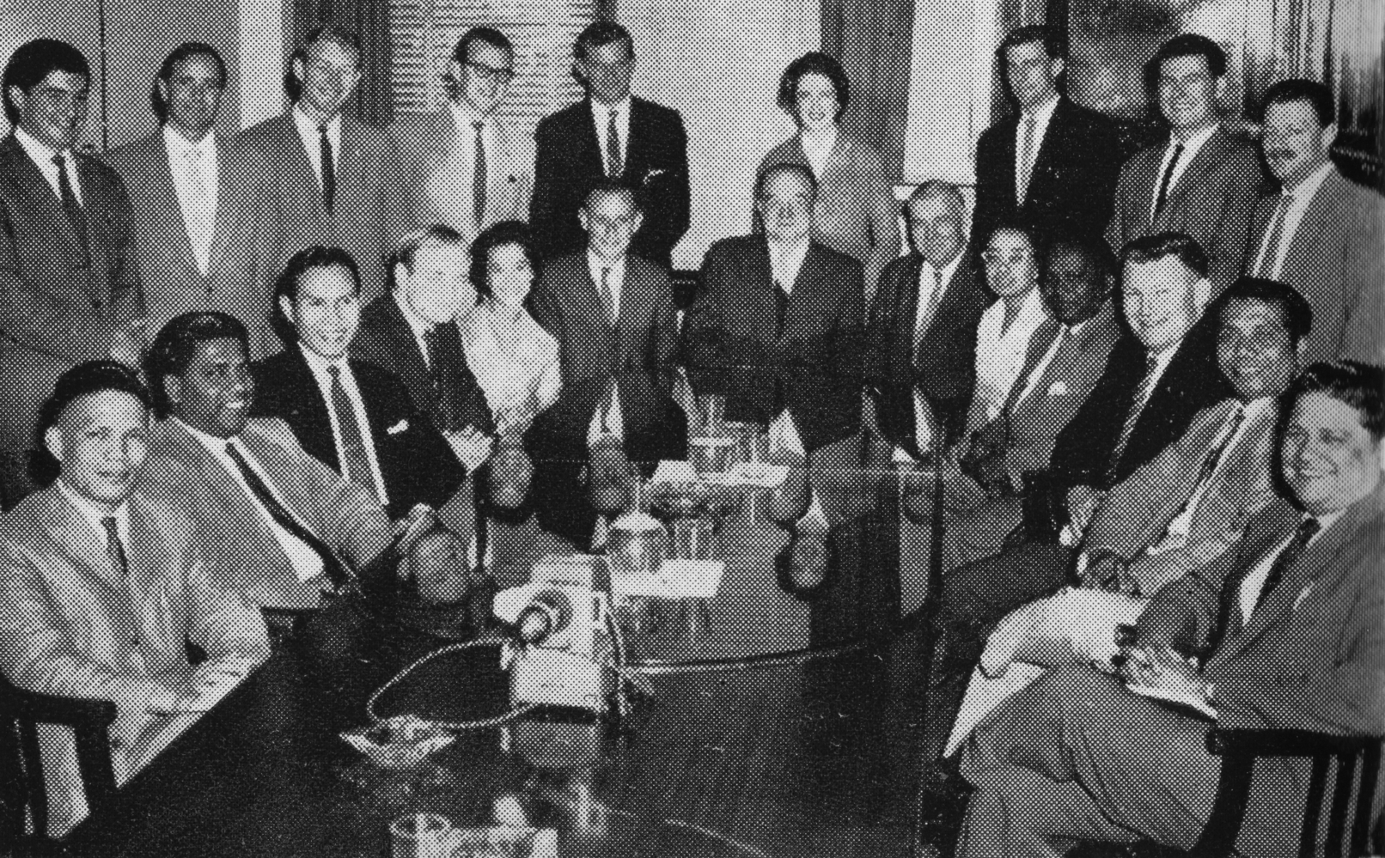 A group, two-deep, around a conference table
